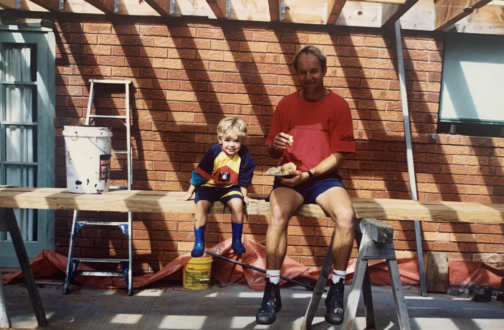 Cooper as a young child on a construction site with his dad, who built their family home.